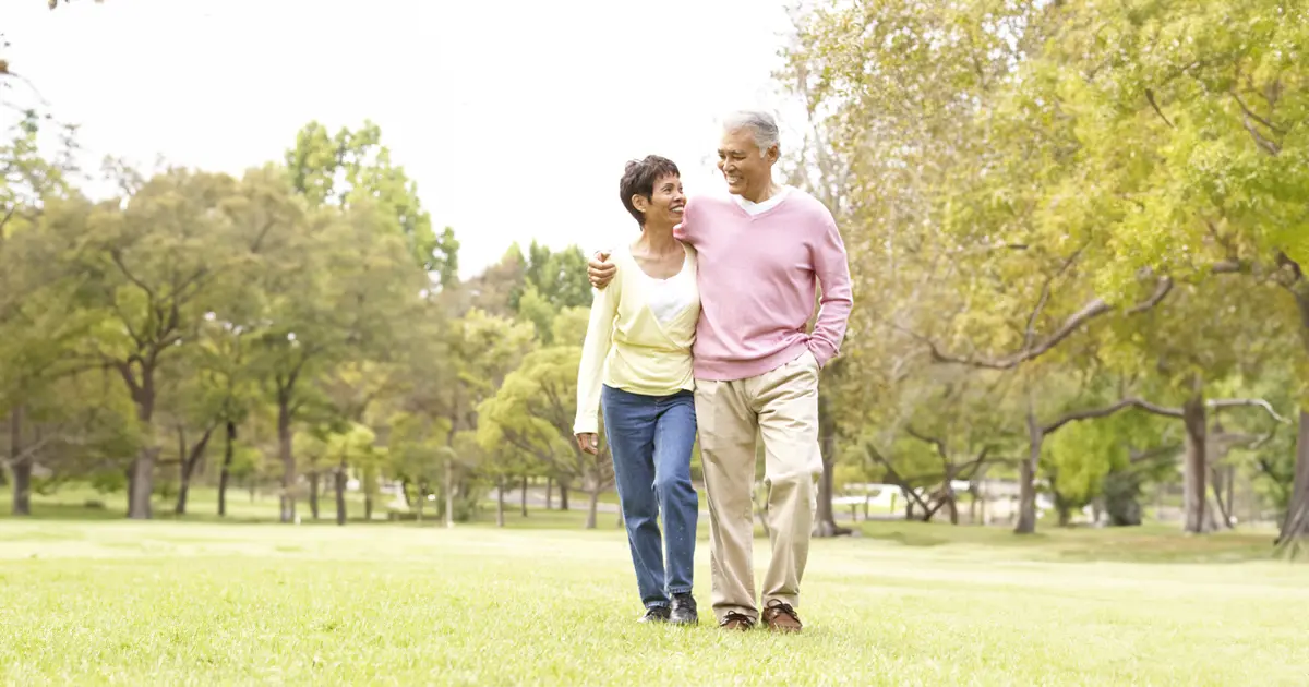 A healthy couple walking in the park implementing balance in their lifestyle