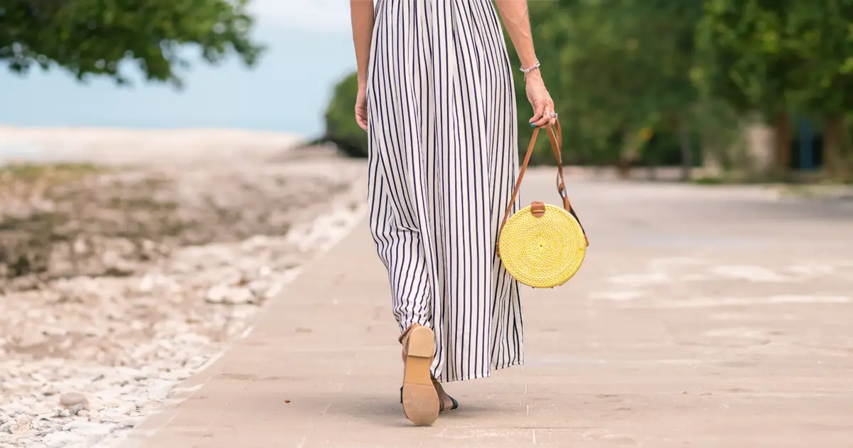 Woman in long casual skirt walking along beach