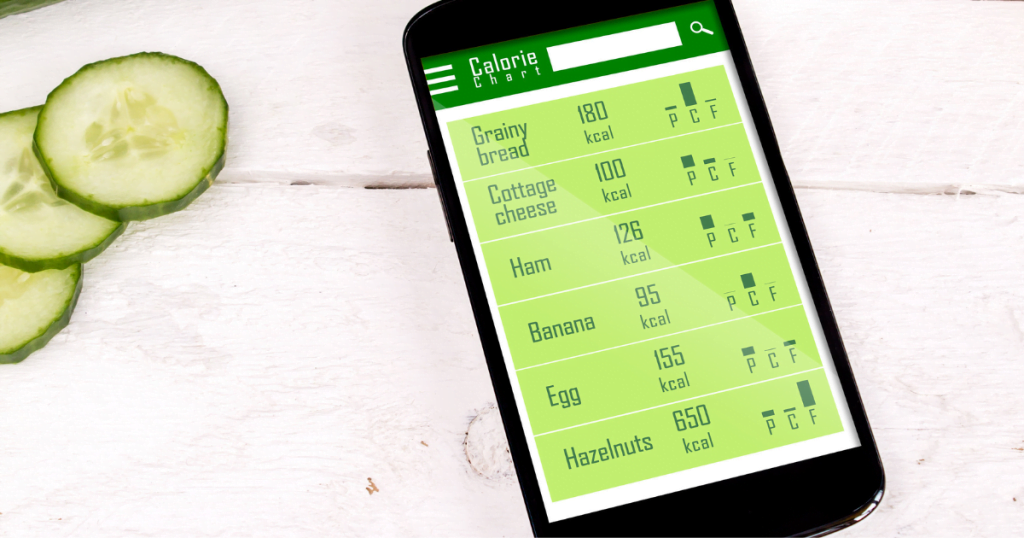 A calorie counting app on a mobile phone sitting on a bench surrounded by fruit and vegetables 