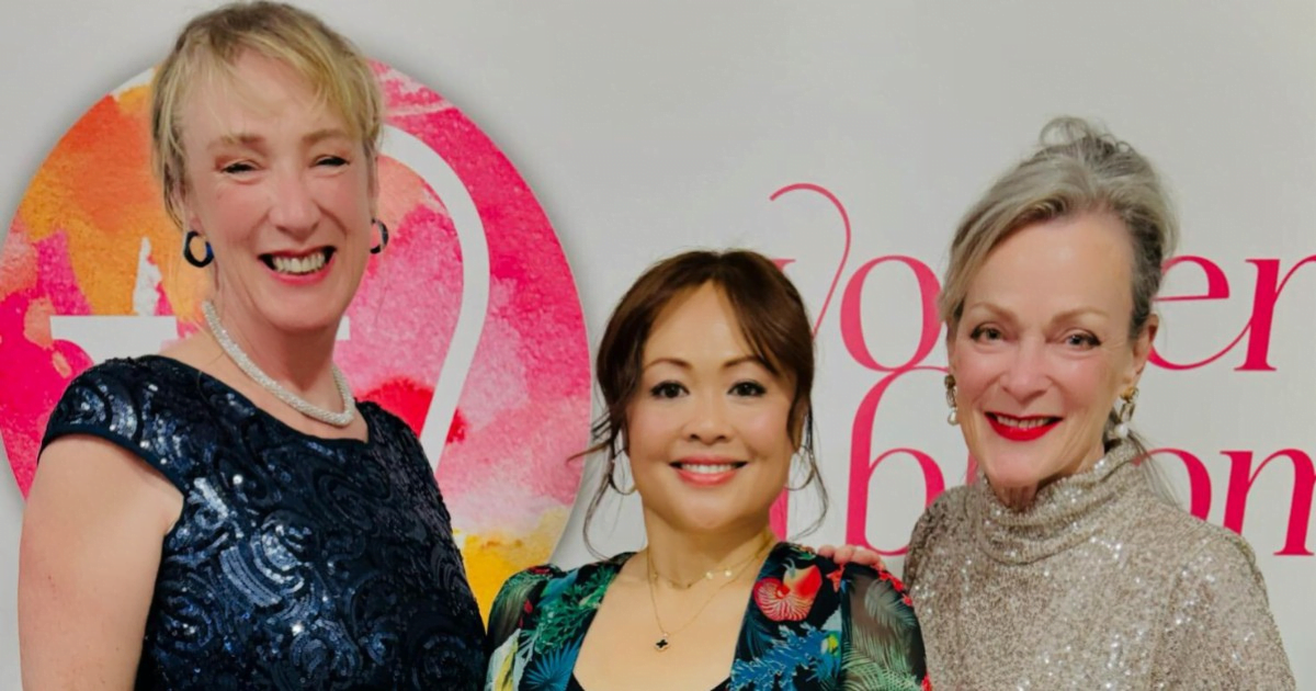 From left to right, Caroline, Alexis and Annie dressed up to go out in front of the Women in Bloom sign.