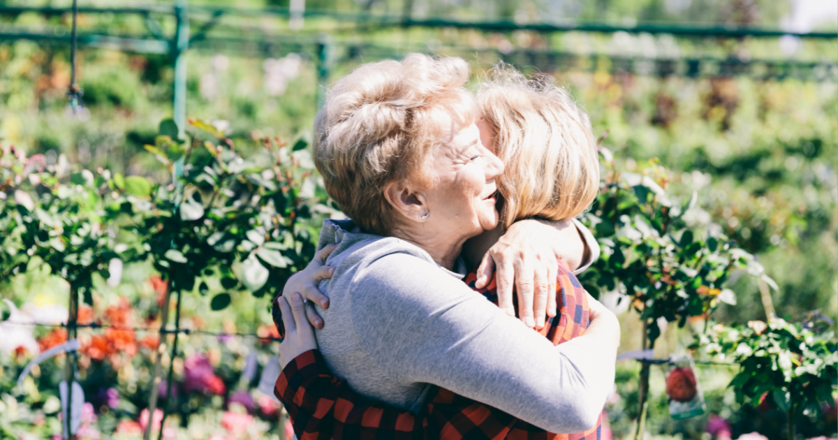 A middle-aged woman spreading kindness by hugging her friends and encouraging connection.