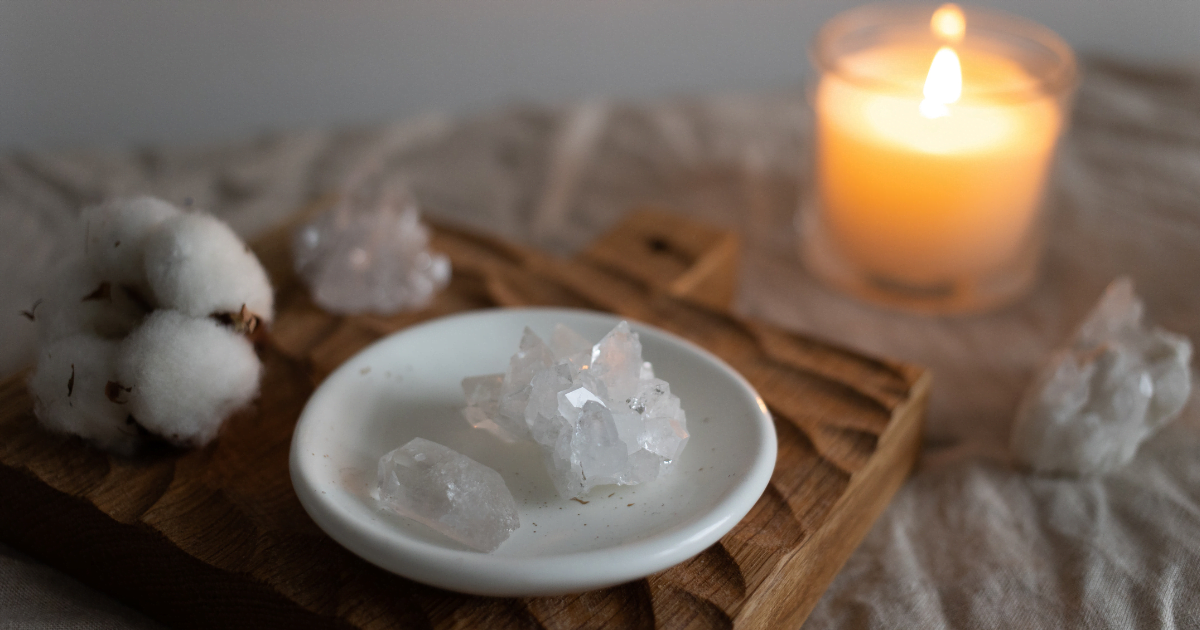 A candle and crystals decorated together to bring a sense of peace and mindfulness which will set the atmosphere of meditation and journaling.